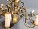a brass chandelier with three candles on it