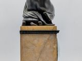 an image of a statue of a woman sitting on top of a marble block