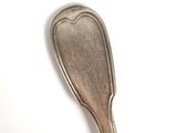 a silver spoon with a heart on it on a white surface