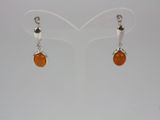 a pair of earrings with orange glass beads on a white background