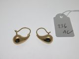deux paires de boucles d'oreilles en or avec une étiquette sur un fond blanc