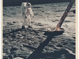 une vieille photo d'un astronaute debout sur la Lune, à côté d'une pelle