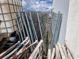 une clôture située à côté d'un bâtiment, avec une voiture en arrière-plan