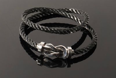 un gros plan d'un bracelet orné d'un nœud sur un fond noir