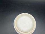 a white bowl sitting on top of a black table