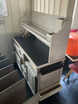 une cuisine avec un plan de travail noir et une chaise rouge
