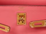 a close up of a pink purse with gold hardware