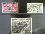 Plusieurs timbres différents sont exposés dans une vitrine.