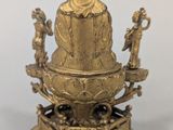 an image of a gold statue of a person sitting on a pedestal