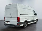 the back of a white van parked in a large room