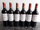 six bottles of wine are lined up on a table