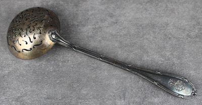 une cuillère en argent avec un manche de cuillère sur une table