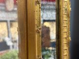 le reflet d'un bâtiment dans un cadre doré