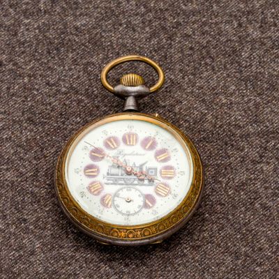 une montre de poche posée sur une surface marron