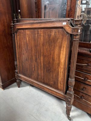 un lit avec un cadre en bois et un miroir accroché au mur