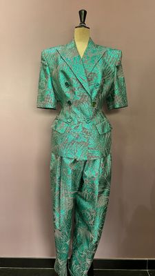 un mannequin vêtu d'un costume vert composé d'un haut et d'un pantalon noirs