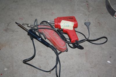 a red and black blow dryer sitting on the ground