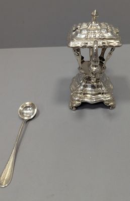 une assiette en argent avec une cuillère et un repose-cuillère posés sur une table