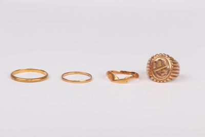trois bagues en or et une bague sur un fond blanc