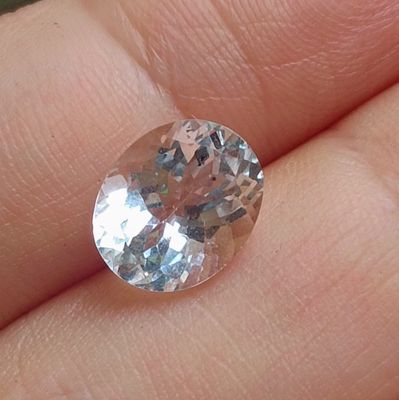 une personne tenant dans sa main un très joli diamant rose