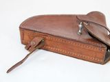 a brown leather case with a handle on a white surface