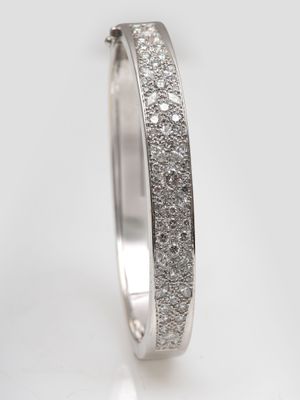 un gros plan d'une alliance sertie de diamants sur fond blanc