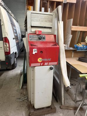 a machine that is sitting in a garage next to a van