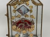 une vitrine contenant un objet doré et rouge