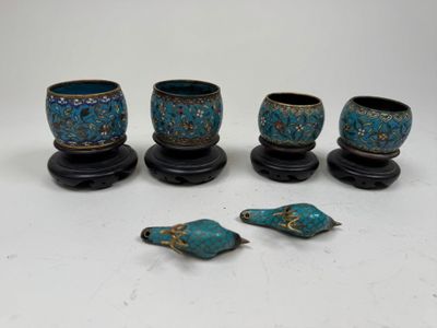 four pieces of blue pottery with gold accents on a white surface