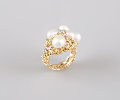 une bague en or ornée de perles et de diamants sur fond blanc