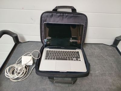 a laptop computer sitting in a suitcase on the floor