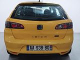 the rear end of a small yellow car parked in a garage