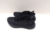 a pair of black adidas sneakers on a white surface