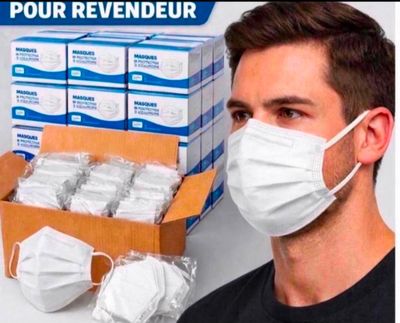 un homme portant un masque à côté d'une boîte de masques