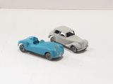 two toy cars sitting next to each other on a white surface