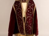 un gros plan d'une robe rouge et dorée sur un mannequin