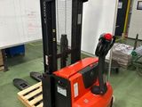 un chariot élévateur rouge dans un entrepôt avec des palettes