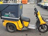 a scooter with a box on the back parked in a parking lot
