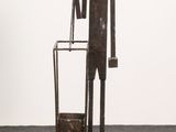 sculpture of a man standing next to a trash can and a trash can
