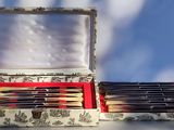 a box of pens and pencils sitting on top of a table