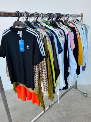 des vêtements suspendus à un portant dans un magasin de vêtements, avec une étiquette de prix