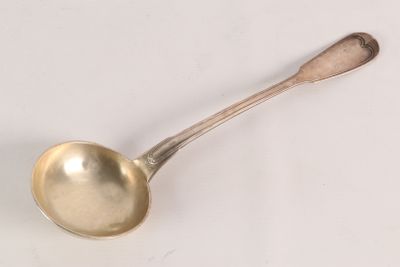 a silver spoon with a spoon handle on a white surface