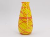 a yellow and red vase sitting on a white surface