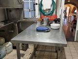 a kitchen with a stainless steel table in the middle of the room