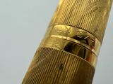 a close up of a gold fountain pen with a white background