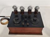 an old fashioned electronic device with four different knobs and a wooden base