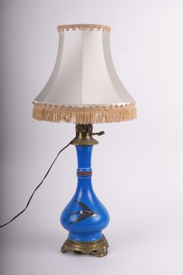 une image représentant une lampe bleue surmontée d'un abat-jour blanc