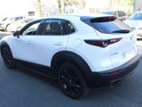 the rear end of a white mazda cx - hr parked in a parking lot