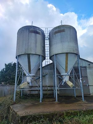 deux silos situés sur le côté d'un bâtiment, avec le ciel en arrière-plan