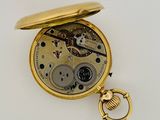 an image of a gold pocket watch with a key on a white surface